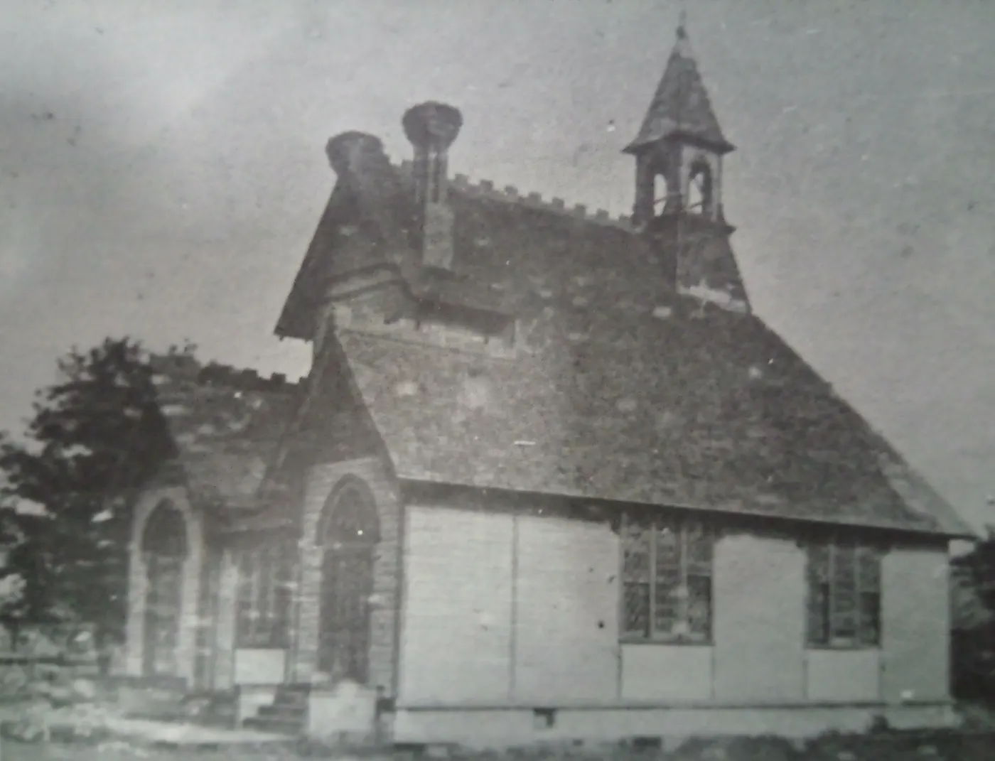Black and white photograph of the original Mitchellville First Congregational Church building, a wooden church with a steep roof, arched entry and tall windows